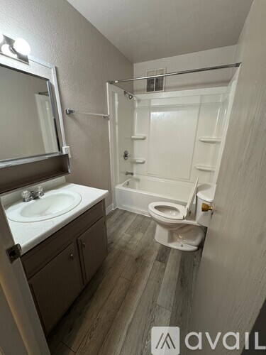 A bathroom with a toilet, sink, and mirror.