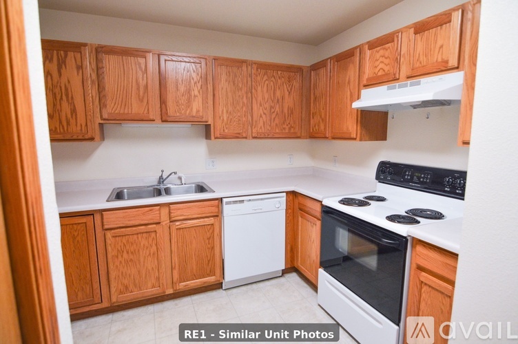 A kitchen with wooden cabinets and white appliances.