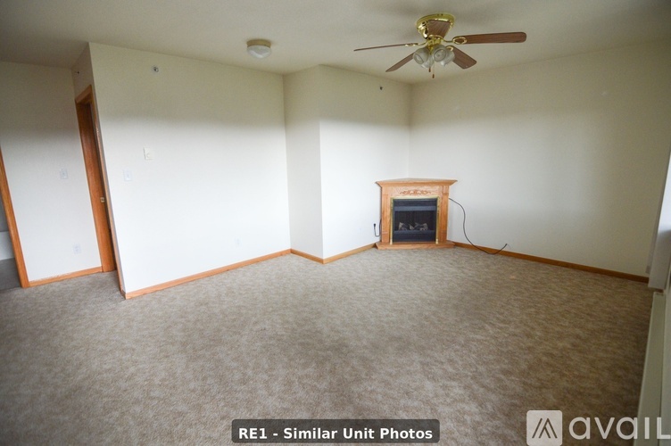 A room with a fireplace and a ceiling fan.