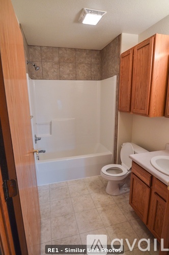 A bathroom with a toilet, sink, and bathtub.