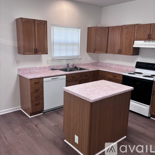 A kitchen with wooden cabinets and a pink countertop.