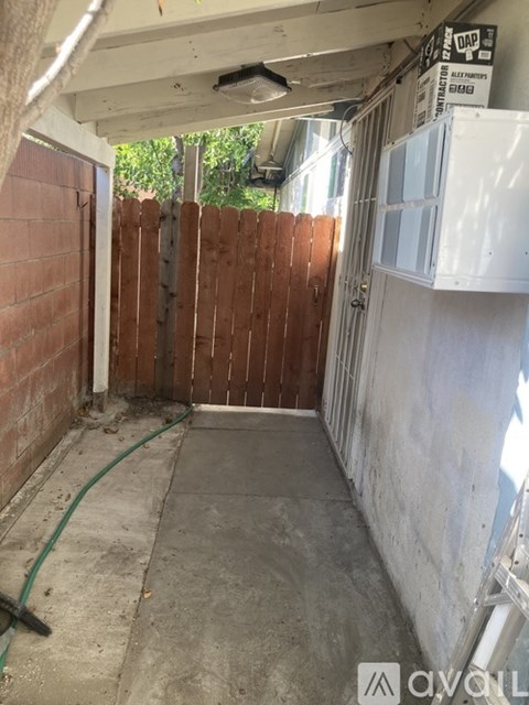 A room with a white wall and a wooden fence in the background.