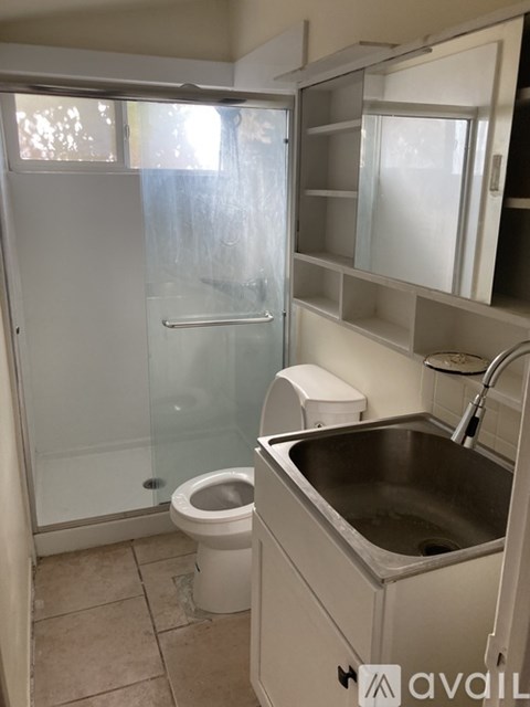 A small bathroom with a toilet, sink and shower.