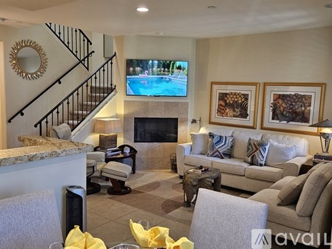A living room with a fireplace and a television on the wall.