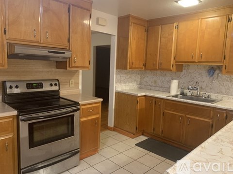 A kitchen with wooden cabinets and a stove top oven.