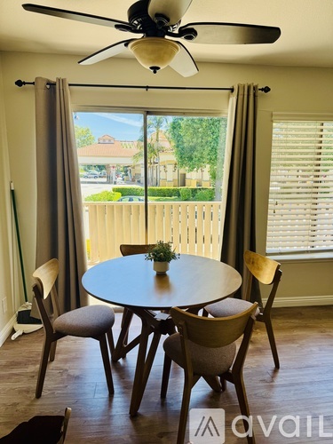 A dining room with a table and chairs and a ceiling fan.