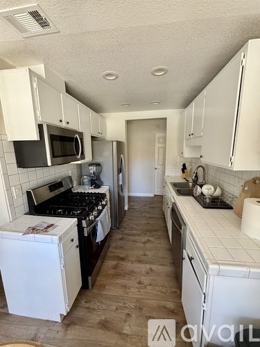 A kitchen with white cabinets and a black stove top.