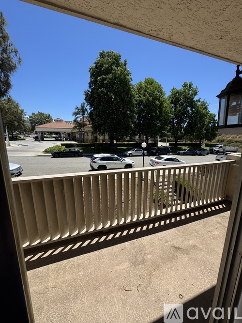 A parking lot with cars and trees in the background.