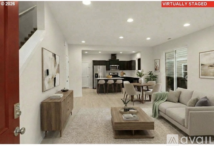 A modern living room with a staircase on the left and a dining area in the background.