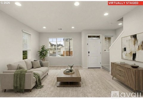 A living room with a couch, coffee table, and a painting on the wall.