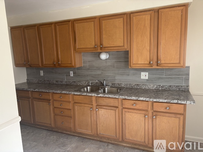 A kitchen with wooden cabinets and a granite countertop.