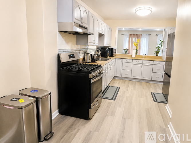 A modern kitchen with a black stove and white cabinets.