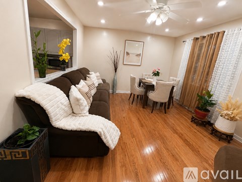 A living room with a brown couch and a white blanket on it.