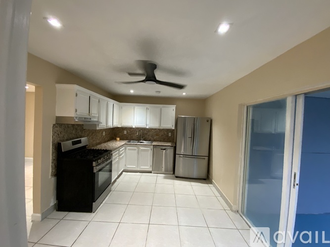 A kitchen with black appliances and white cabinets.