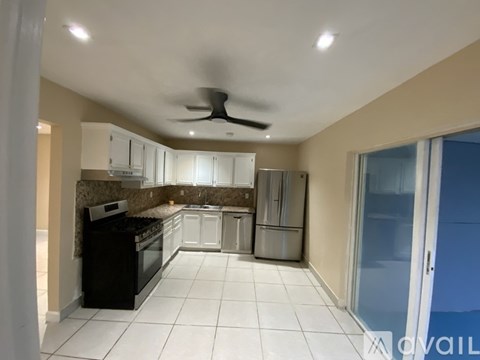 A kitchen with black appliances and white cabinets.