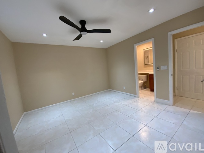 A room with a ceiling fan and tile flooring.