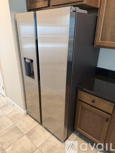 A white refrigerator with a black handle is in a kitchen.
