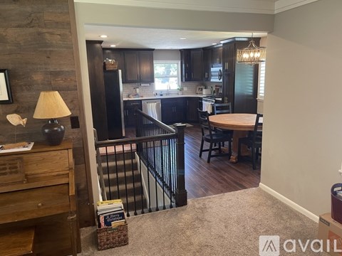A kitchen with a dining table and chairs is visible from the living room.