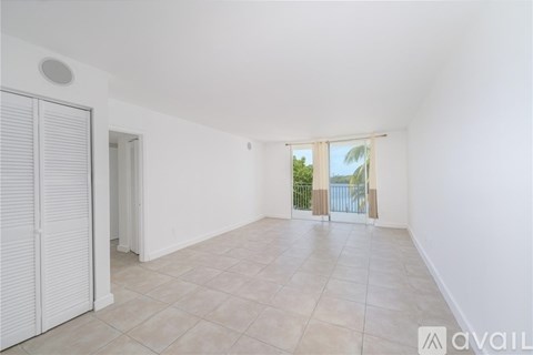 A spacious room with white walls and a tiled floor.