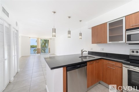 A kitchen with wooden cabinets and black countertops.