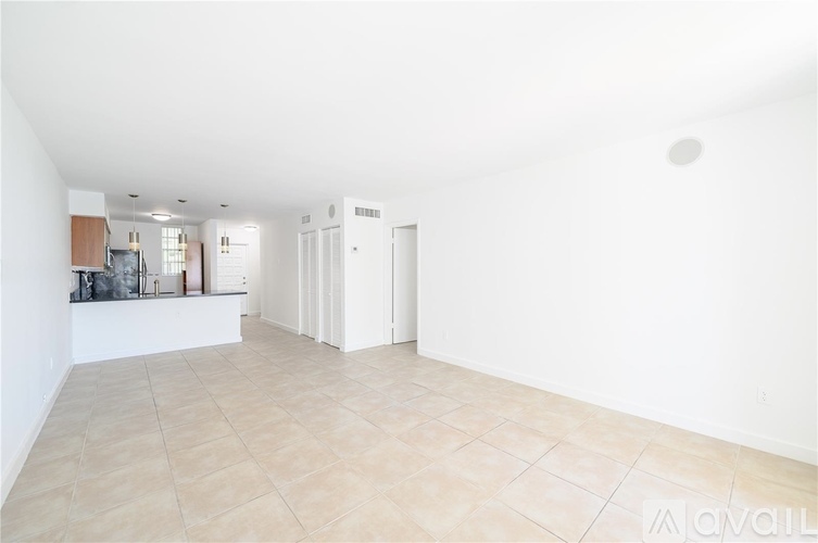 A spacious room with white walls and a tiled floor.