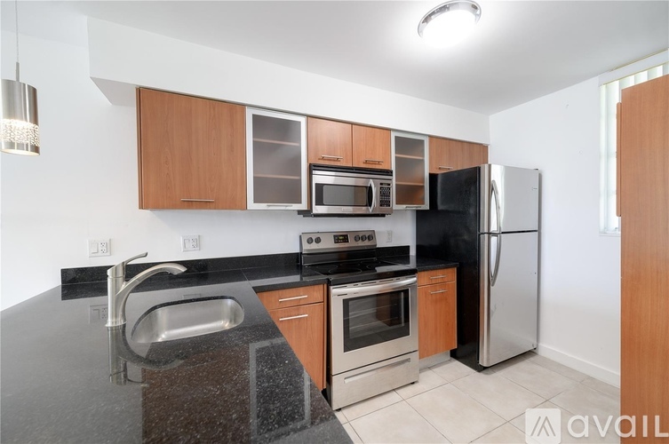 A kitchen with a black granite countertop and stainless steel appliances.