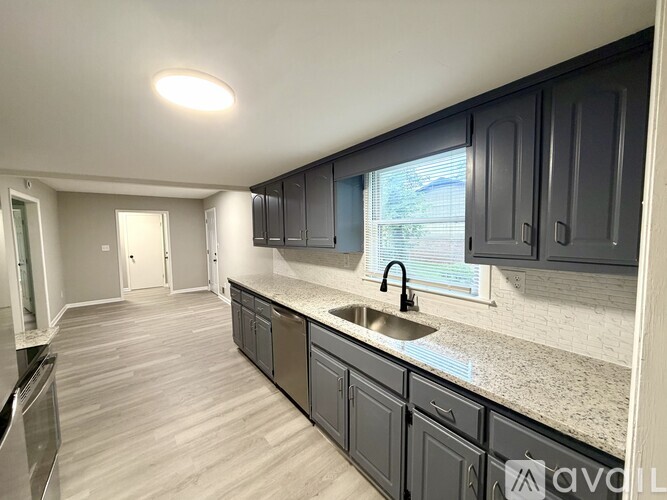 A kitchen with dark cabinets and a sink.