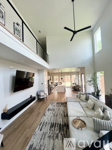 A modern living room with a grey rug and a white sofa.
