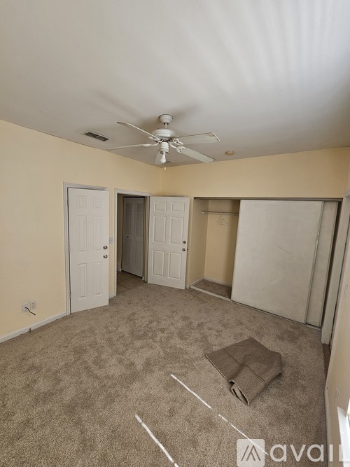 A room with a ceiling fan and carpeted floor.