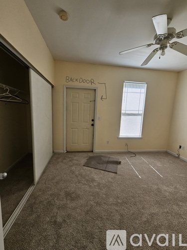 A room with a ceiling fan and a door labeled "Back Door".