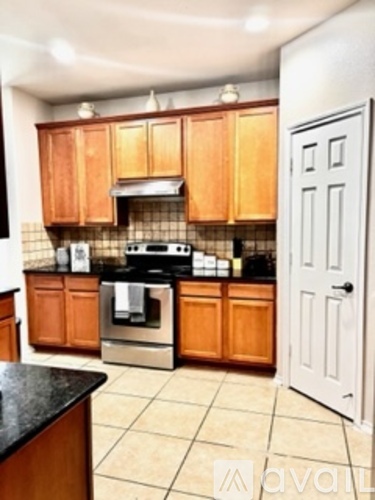 A kitchen with wooden cabinets and a black countertop.