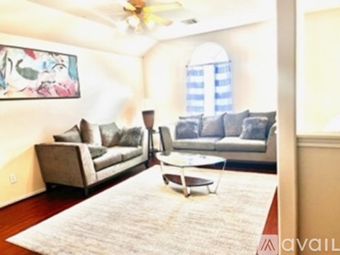 A living room with a grey couch and a white coffee table.