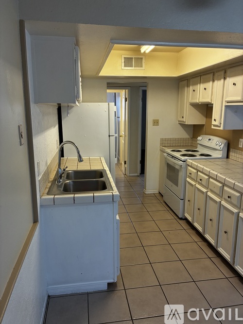 A kitchen with white appliances and a white sink.