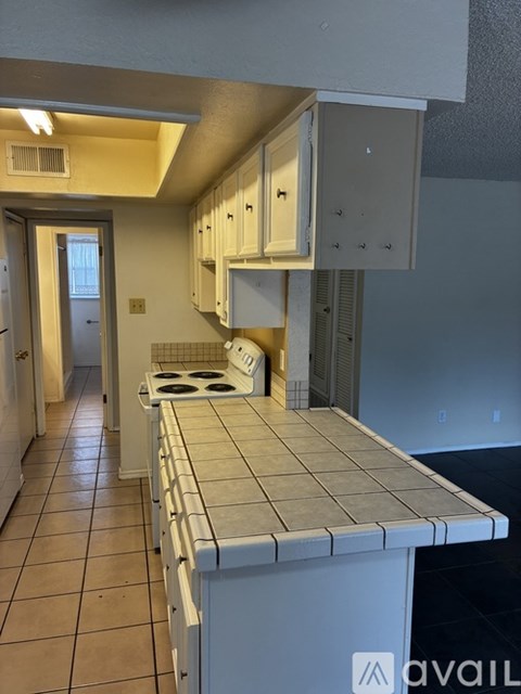 A kitchen with a white counter and cabinets.