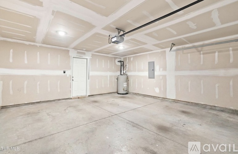 A spacious garage with a concrete floor and walls under construction.