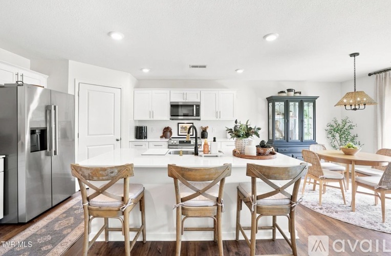 A modern kitchen with a dining table set for four.