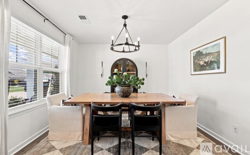 A dining room with a wooden table and chairs.