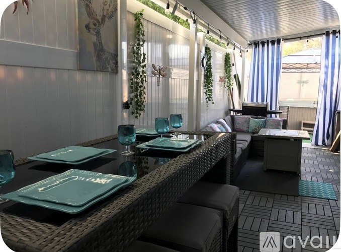 A dining area with a table set for two and a sofa.