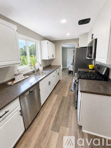 A kitchen with white cabinets and a brown countertop.