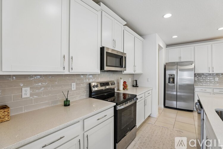 A kitchen with white cabinets and appliances.