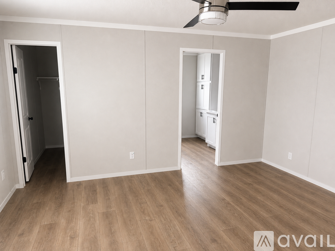 A room with a ceiling fan and wooden flooring.