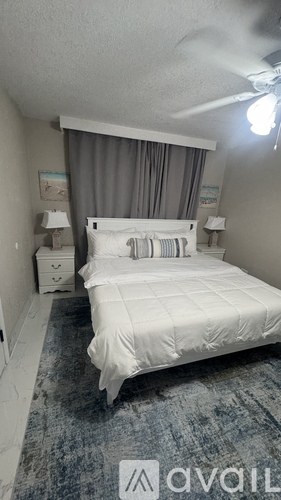 A bedroom with a large bed and a ceiling fan.