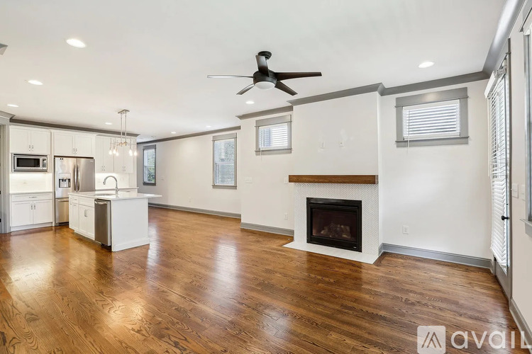 A spacious living room with a fireplace and hardwood floors.