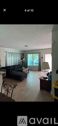 A living room with a black couch and a coffee table.
