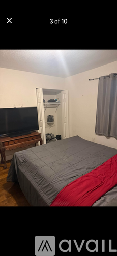 A bedroom with a bed, a television, and a wardrobe.