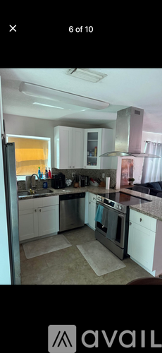A kitchen with white cabinets and stainless steel appliances.