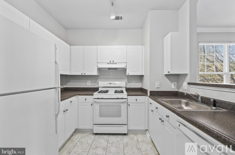 A kitchen with white cabinets and appliances.