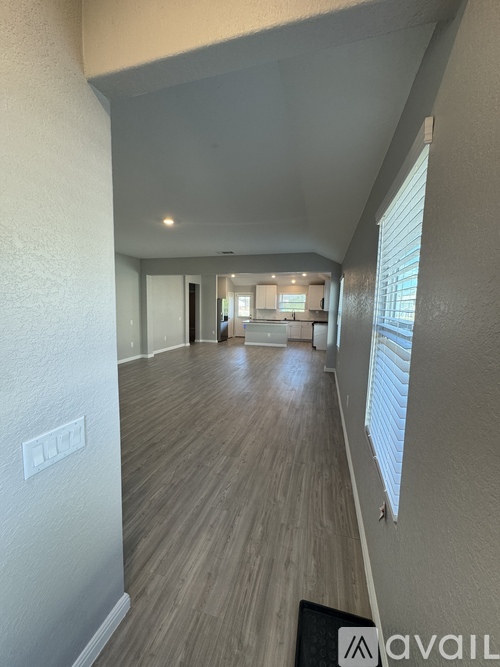 A hallway with wooden floors and white walls.