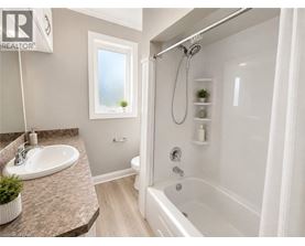 A bathroom with a white tub, sink, and shower.