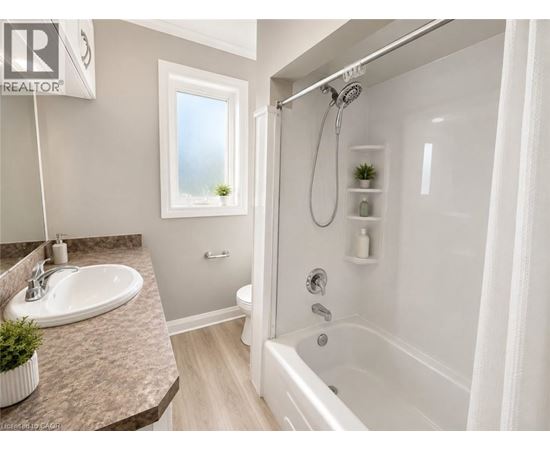 A bathroom with a white tub, sink, and shower.